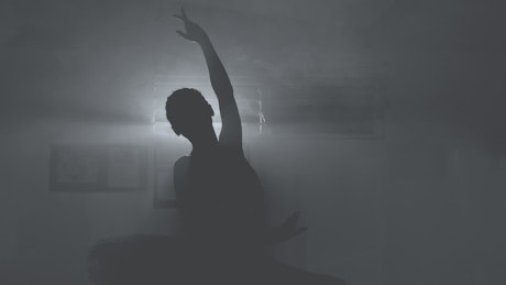 Silhouette of a ballet dancer doing figures.