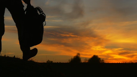 Silhouette of a man at a computer at sunset