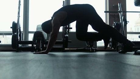 Silhouette of a man doing push-ups.