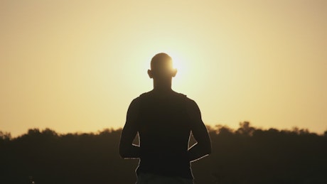 Silhouette of a man looking at the sunset