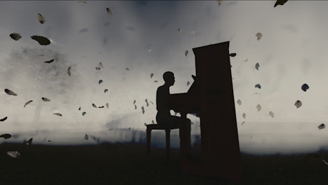 一个男人在黑暗中弹钢琴的剪影