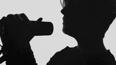 Silhouette of a man singing with a microphone.