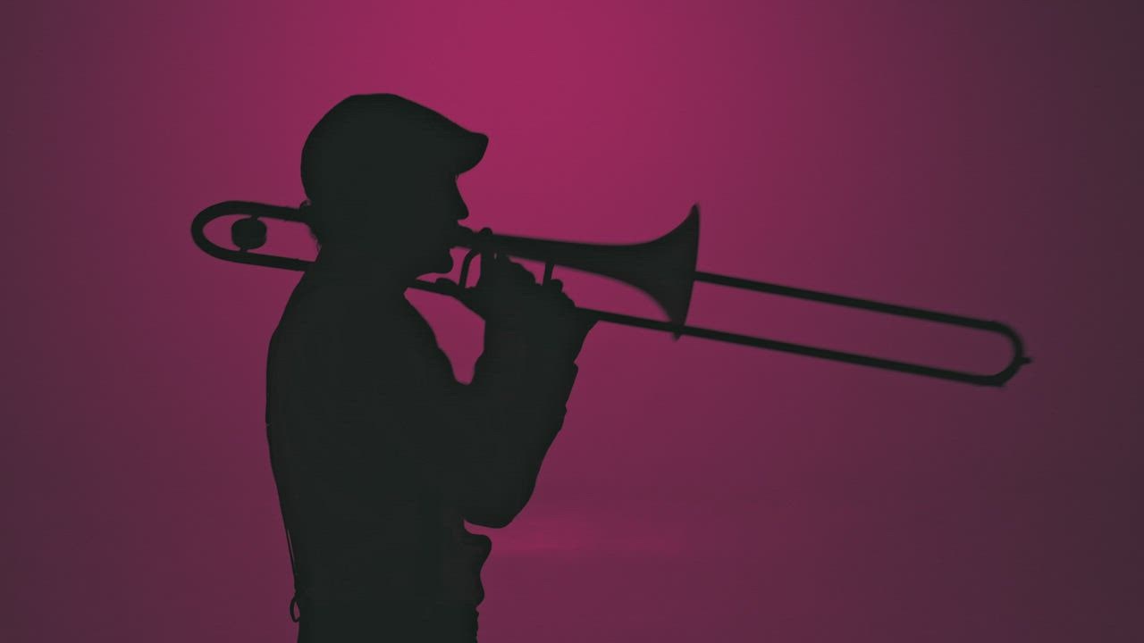 Silhouette of a trumpet player energetically playing - Free Stock Video