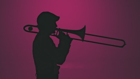 Silhouette of a trumpet player energetically playing