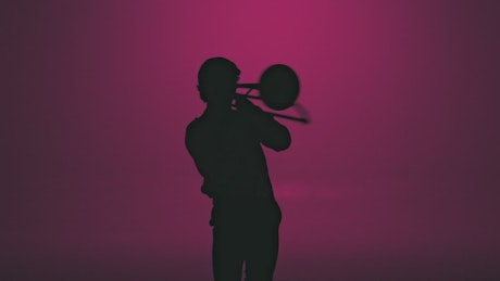 Silhouette of a trumpet player playing with passion.