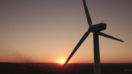Silhouette of a wind turbine at sunset.