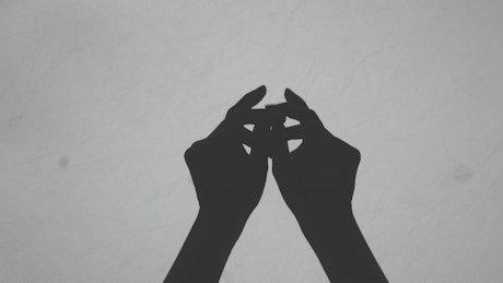 Silhouette of a woman's hands moving them gently