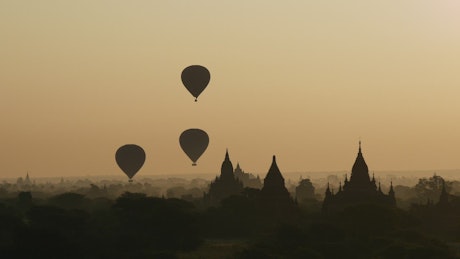 Silhouette of balloons over a city