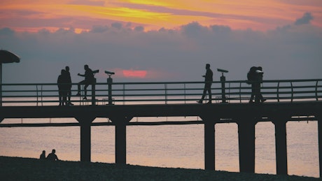 Silhouette of people on the beach pier.