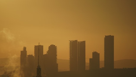 Silhouette of tall buildings in the sunset.