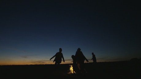 Silhouettes of people in the campfire.