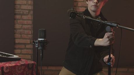 Singer arranging her microphones in a recording studio.