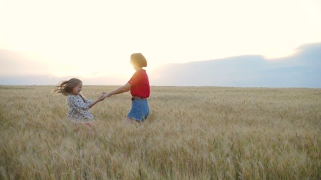 Sisters playing on a wheat field.