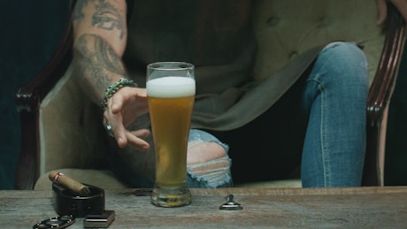 Sitting man drinking beer.