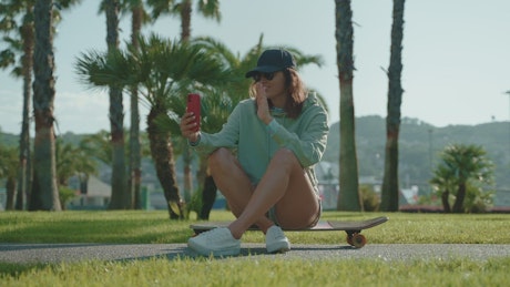 Skater girl in the park having a video call.