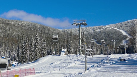 Ski lift operating on a snowy mountain top.