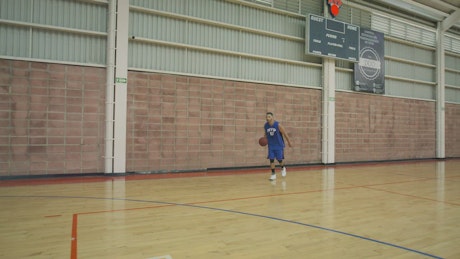 Skilled basketball player training dunk.