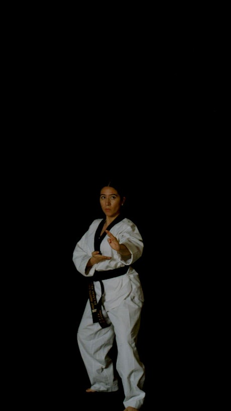 Skilled karate woman making punches in the air with skill.