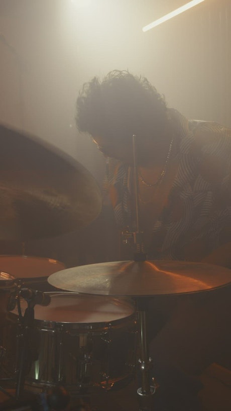 Skillful drummer playing in the dark