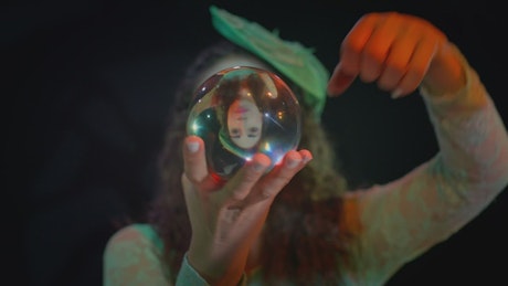 Skillful woman doing tricks with a crystal ball.
