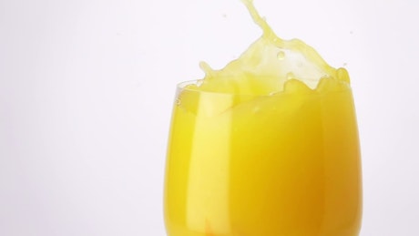 Slice of orange falling into the juice