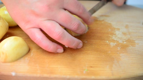 Slicing raw potatoes on a table