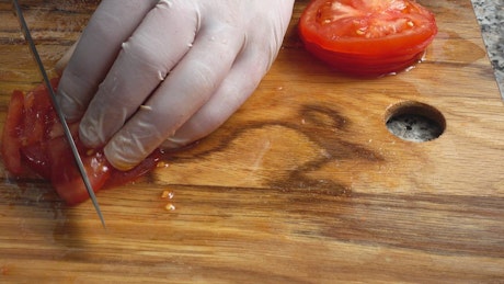 Slicing tomato on a board.
