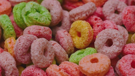 Slowly rotating colored sugary rings cereal.