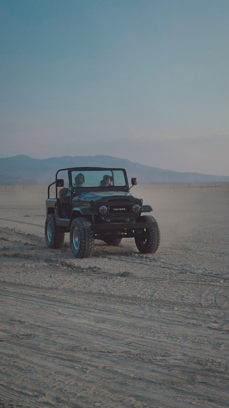 Small pickup truck in a wide dirt desert.