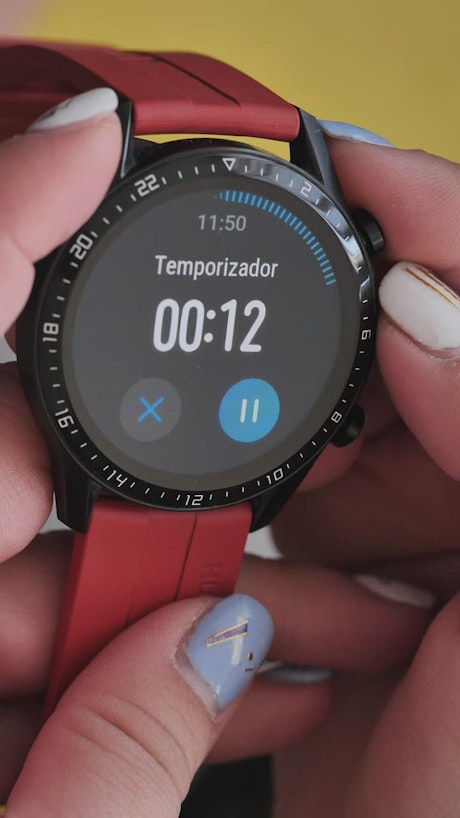 Smart watch with timer held by a woman.