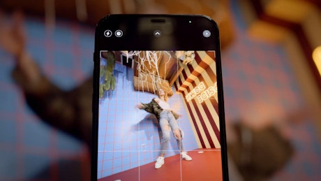 Smartphone recording a young blonde woman in an upsidedown room environment.