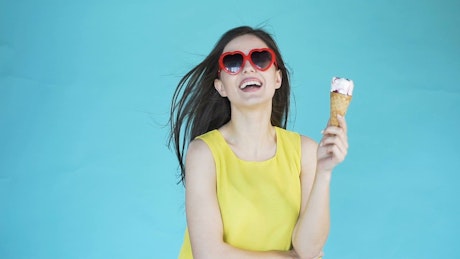 Smiling model holding ice cream on blue background