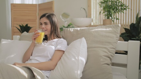 Smiling woman drinking orange juice.