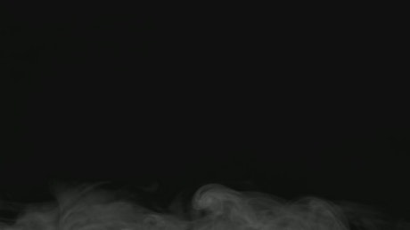 Smoke rising in a dark room