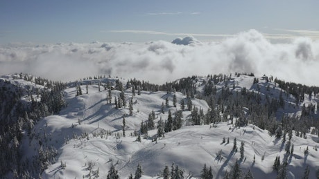 Snow-covered mountain above the clouds.