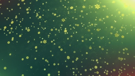Snowing golden snowflakes on green background.