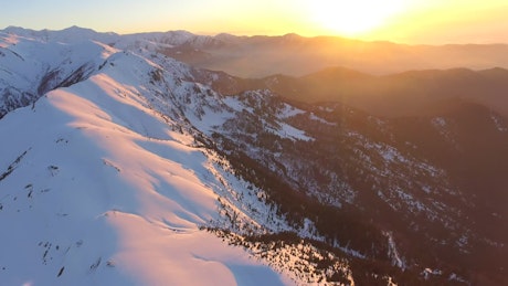 Snowy mountain peak in the sunset