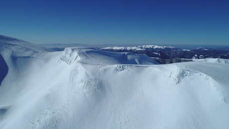 Snowy mountain range seen on a clear sky day