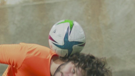 Soccer player juggling a ball with his head