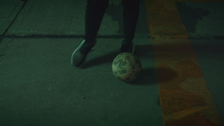 Soccer players dribbling with the ball on pavement