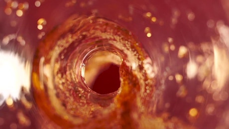 Soda coming out of a bottle seen from the inside