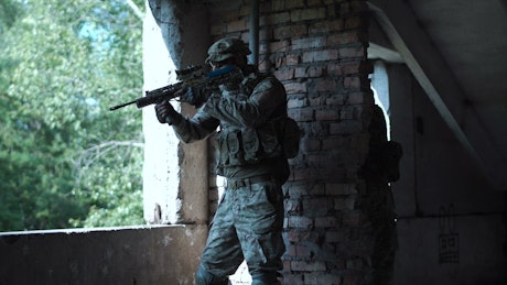 Soldier near a window in an abandoned building.