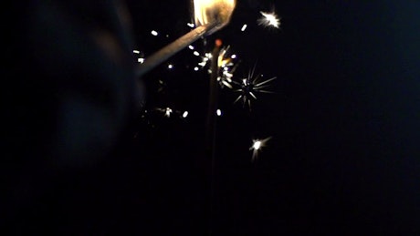 Sparkler being lit with a match.