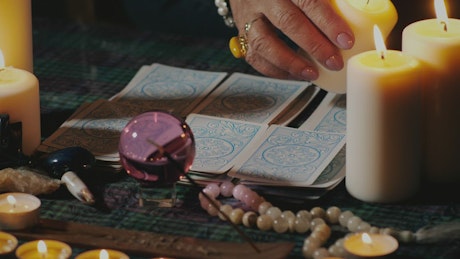 Spiritualist reading tarot cards surrounded by candles.