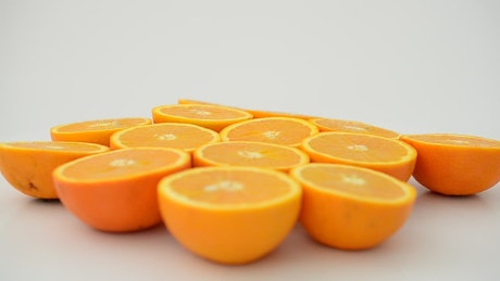 Split oranges rotating on a white background