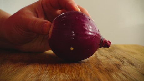 Splitting a purple onion in half.