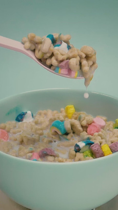 Spoonful of cereal with marshmallows and milk.