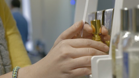 Spraying a perfume sample in a store.