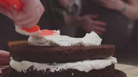 Spreading cream on a chocolate cake