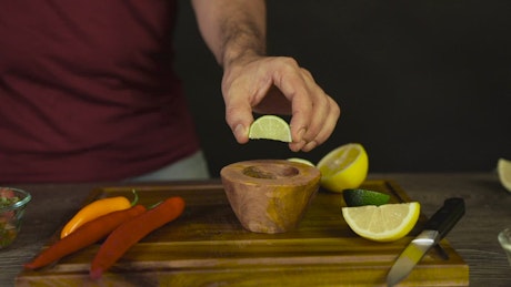 Squeezing lime into a bowl.